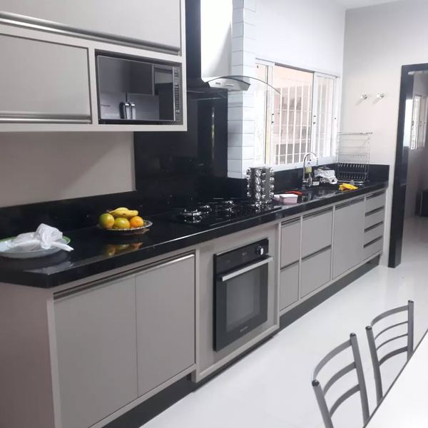 Cozinha com bancada em granito preto e forno embutido