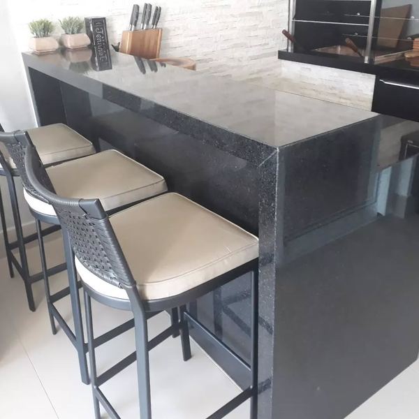 Balcão de bar em granito escuro com banquetas