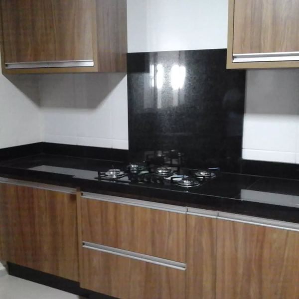 Bancada em granito preto com frontão alto atrás do cooktop