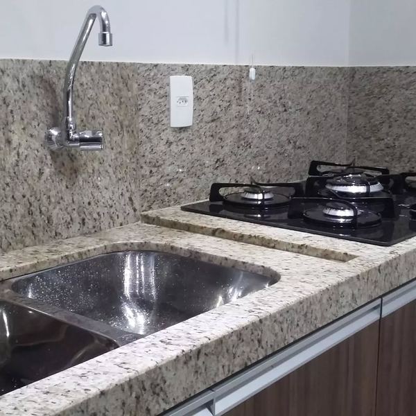 Bancada e frontão em granito claro com cuba de inox