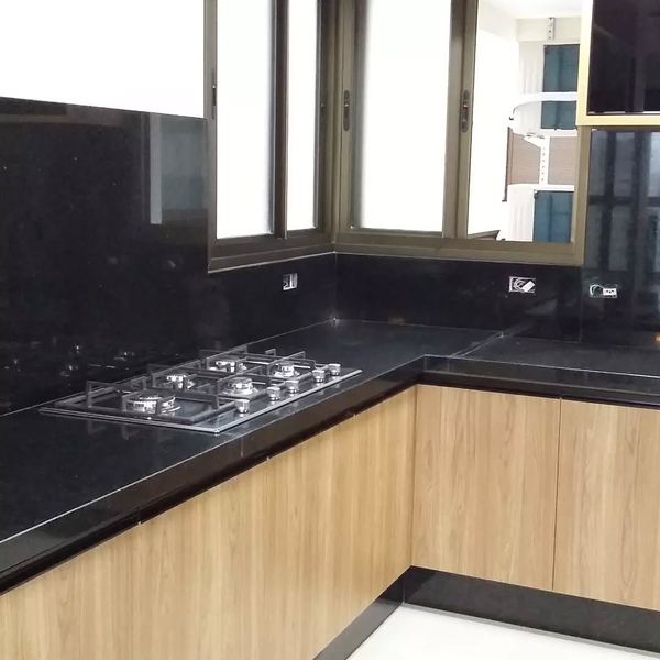 Cozinha em L com bancada e frontão em granito preto